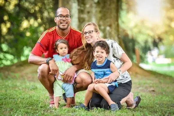 A multiracial family smiling together outdoors